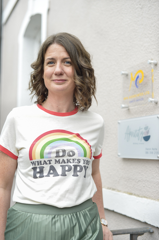 Wellbeing practitioner - woman smiling wearing tshirt with 'do what makes you happy' quote